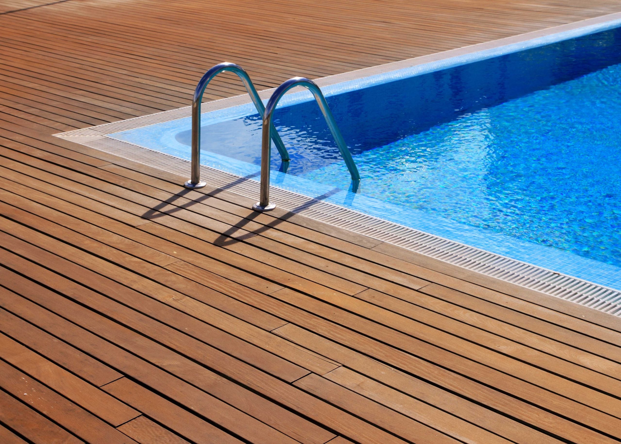 A wrap around deck is installed with a pool on a residential property.